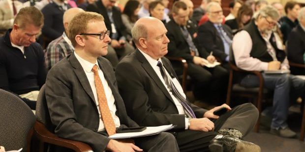 Alex Adams, Gov. Brad Little's budget chief, (left) and House Speaker Mike Moyle, R-Star, (right) attend a hearing on a sweeping bill that would cut income taxes and give schools $200 million annually for construction. (Photo: Darren Svan/EdNews)